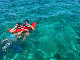 Two young snorkelers enjoy the vibrant underwater world while floating in crystal-clear waters, showcasing the excitement of marine exploration.