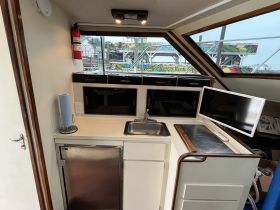 Interior view of a boat's helm area featuring a sink, storage, and a monitor — ideal for navigation and comfort while on the water.