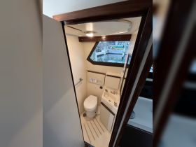 Interior view of a boat bathroom featuring a toilet and sink, showcasing the compact design typical of marine vessels.