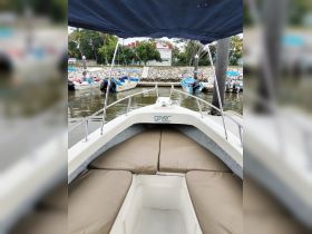 Interior view of a boat's seating area, showcasing comfortable cushions and a clean design, perfect for relaxing while on the water.