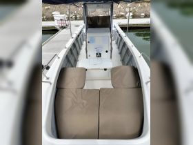 Interior view of a boat's helm and seating area, showcasing comfortable cushions and a clean layout, ideal for a day on the water.