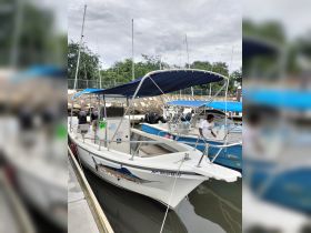 A speedboat named 'El Pescador' docked at the marina, showcasing its sleek design and vibrant graphics. Perfect for fishing trips or leisurely cruises.