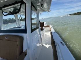 A view of the interior of a boat showcasing comfortable seating and helm area, perfect for enjoying a day on the water.