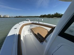 Interior view of a sleek boat showcasing comfortable seating and helm area, perfect for a day on the water.