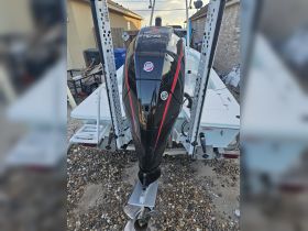 Close-up view of an outboard motor on a boat, showcasing its sleek design and features, ideal for boating enthusiasts and potential buyers.