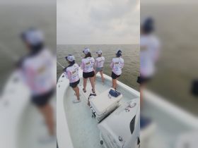 A group of women enjoy a fishing trip on a boat, casting their lines into the ocean — a perfect day for fishing enthusiasts.