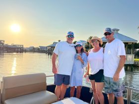 A cheerful group enjoys a sunset on a pontoon boat, capturing a memorable moment together on the water.