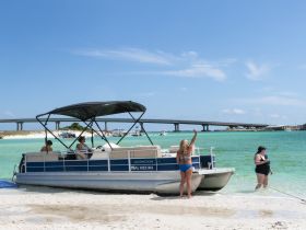 A fun day at the beach with friends enjoying a pontoon boat, swimming in the clear waters, and soaking up the sun — perfect for summer outings.