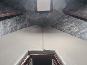 Interior view of a cozy boat cabin featuring comfortable seating, perfect for relaxing during your nautical adventures.
