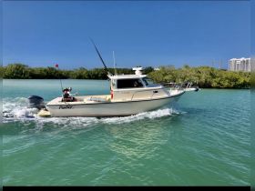 Two friends enjoy a fishing trip aboard a Parker boat, navigating through beautiful turquoise waters — a perfect day on the water.