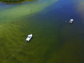 Aerial view of two boats navigating through shallow waters, showcasing the serene beauty of the landscape.