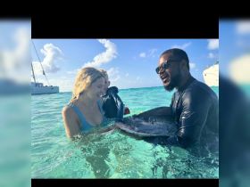 A memorable encounter as guests interact with a stingray in the crystal-clear waters, showcasing the thrill of wildlife experiences in the Bahamas.