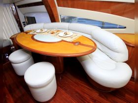 Interior view of a stylish dining area on a boat, featuring elegant seating and a beautifully set table, perfect for enjoying meals while cruising.