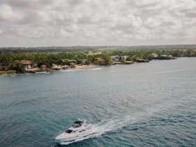 A stunning aerial view of a yacht cruising through clear waters, with a picturesque coastline in the background, perfect for showcasing luxury boating experiences.
