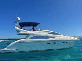 A sleek yacht glides through crystal-clear waters, showcasing its elegant design and perfect for luxurious outings on the sea.