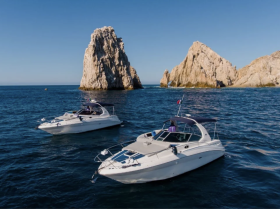 A stunning aerial view of two yachts cruising near dramatic rock formations, showcasing the beauty of the coastline and perfect for luxury boating experiences.