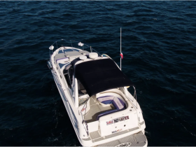 Aerial view of a sleek yacht named 'Romance' anchored in deep blue waters, showcasing its elegant design and spacious deck — perfect for luxurious outings.