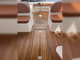 Interior view of a boat's helm and seating area, showcasing elegant wooden flooring and comfortable seating — perfect for a day on the water.