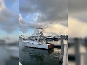 A sleek fishing boat docked at the marina, showcasing its impressive design and fishing gear, perfect for a day on the water.