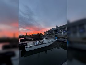 A serene sunset view featuring a docked boat, creating a picturesque scene perfect for evening outings or fishing trips.