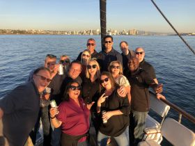 A lively group of friends celebrates on a boat, enjoying drinks and the beautiful waterfront view — perfect for memorable gatherings and parties on the water.
