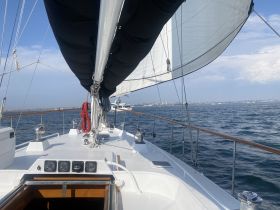 A view from the deck of a sailboat, showcasing the sails and the open water, perfect for sailing enthusiasts and adventure seekers.