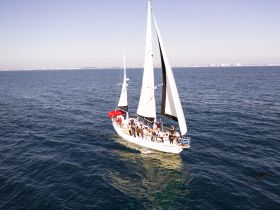 A lively group enjoys a sailing adventure on a beautiful day, showcasing the joy of on-water activities with friends.