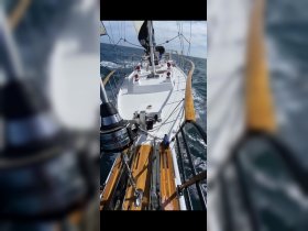 A stunning view of a sailboat underway, showcasing its sleek design and craftsmanship as it navigates through open waters.