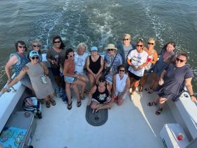 A lively group of friends enjoys a fun day on the water, celebrating together aboard a boat — perfect for memorable outings and gatherings.
