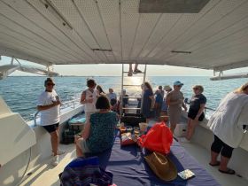 A lively group enjoys a boat party with drinks and snacks, creating a perfect atmosphere for celebration on the water.