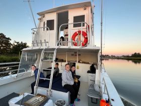 A cheerful group of children enjoys their time aboard a boat, capturing the essence of family fun on the water during sunset.