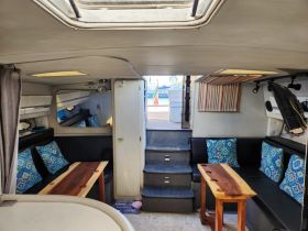 Interior view of a cozy boat cabin featuring comfortable seating and a well-designed helm area, perfect for relaxing during your nautical adventures.