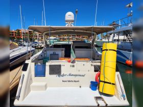 A clear view of the back of a yacht named 'Anchor Management' docked in Nuevo Vallarta, showcasing its structure and amenities.