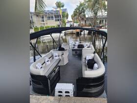 Interior view of a spacious pontoon boat featuring comfortable seating and a lounge area, perfect for relaxing on the water.