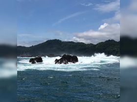 A stunning view of rocky formations surrounded by crashing waves, showcasing the beauty of the ocean landscape.