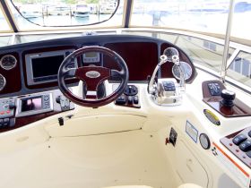 A detailed view of the helm and console inside a boat, showcasing the controls and instruments essential for navigation.