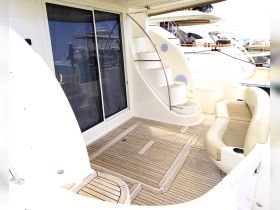 A well-designed interior space of a yacht featuring comfortable seating and a stylish staircase, perfect for relaxing while on the water.