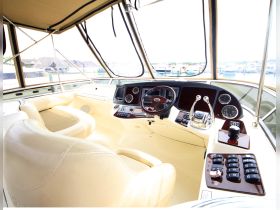 A well-appointed helm area inside a boat, featuring comfortable seating and an array of controls, perfect for navigating the open waters.