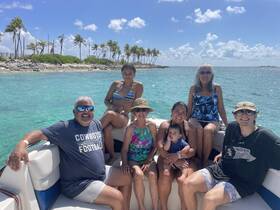 A joyful family gathers on a boat, enjoying a sunny day on the water, perfect for creating lasting memories during their aquatic adventure.