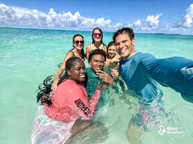 A joyful group of friends enjoys a fun day swimming in crystal-clear waters, capturing memories with smiles and laughter.