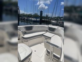 Interior view of a boat's seating area, showcasing comfortable seating and helm space, ideal for relaxing while out on the water.