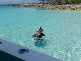 A joyful moment as a man and a child enjoy snorkeling together in the crystal-clear waters, creating unforgettable family memories in a tropical paradise.