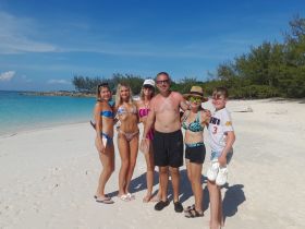 A joyful group of family and friends poses together on a beautiful beach, capturing a memorable moment in paradise.
