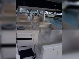 Interior view of a spacious boat cabin featuring comfortable seating and a helm, ideal for relaxing and navigating on the water.