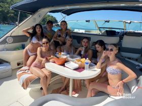 A lively group of friends enjoys a fun day on the boat, sharing snacks and drinks in the sun — perfect for summer celebrations and memorable outings on the water.