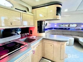 A well-appointed boat interior showcasing a modern kitchen and comfortable seating area, perfect for entertaining guests while cruising.