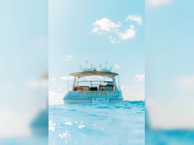 A stunning view of the yacht 'TATA' docked in clear waters, showcasing its elegant design against a bright blue sky — perfect for luxury boating experiences in Key West.