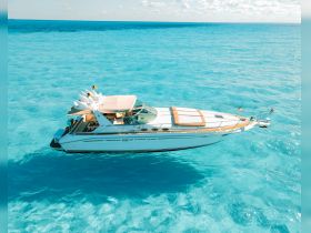 A stunning aerial view of a sleek speedboat gliding through crystal-clear turquoise waters, perfect for luxury charters and island adventures.