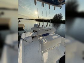 A well-equipped helm area of a Blazer Bay boat, featuring seating and fishing rods, perfect for a day out on the water.