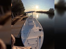 A sleek speedboat docked at sunset, reflecting the warm hues of the sky on calm waters — perfect for fishing or leisure outings.